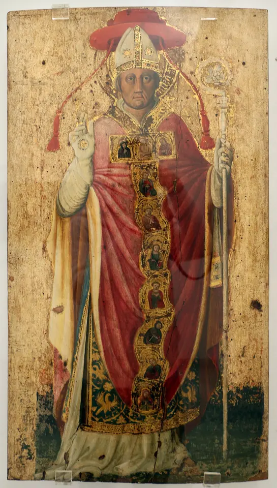 Gothic panel painting of St. Peter Damian standing in a red cardinal's cape over embroidered vestments, wearing a bishop's miter beneath a red cardinal's hat, blessing with one hand and holding a crozier