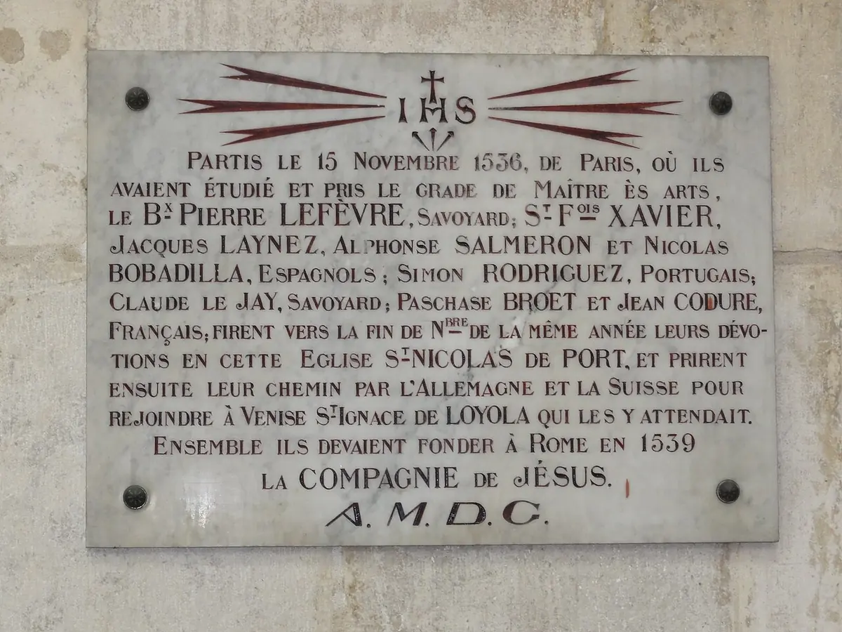 Marble plaque headed with the letters IHS listing Blessed Pierre Lefèvre, Francis Xavier and their companions, who prayed in the church in November 1536 on their way to Venice