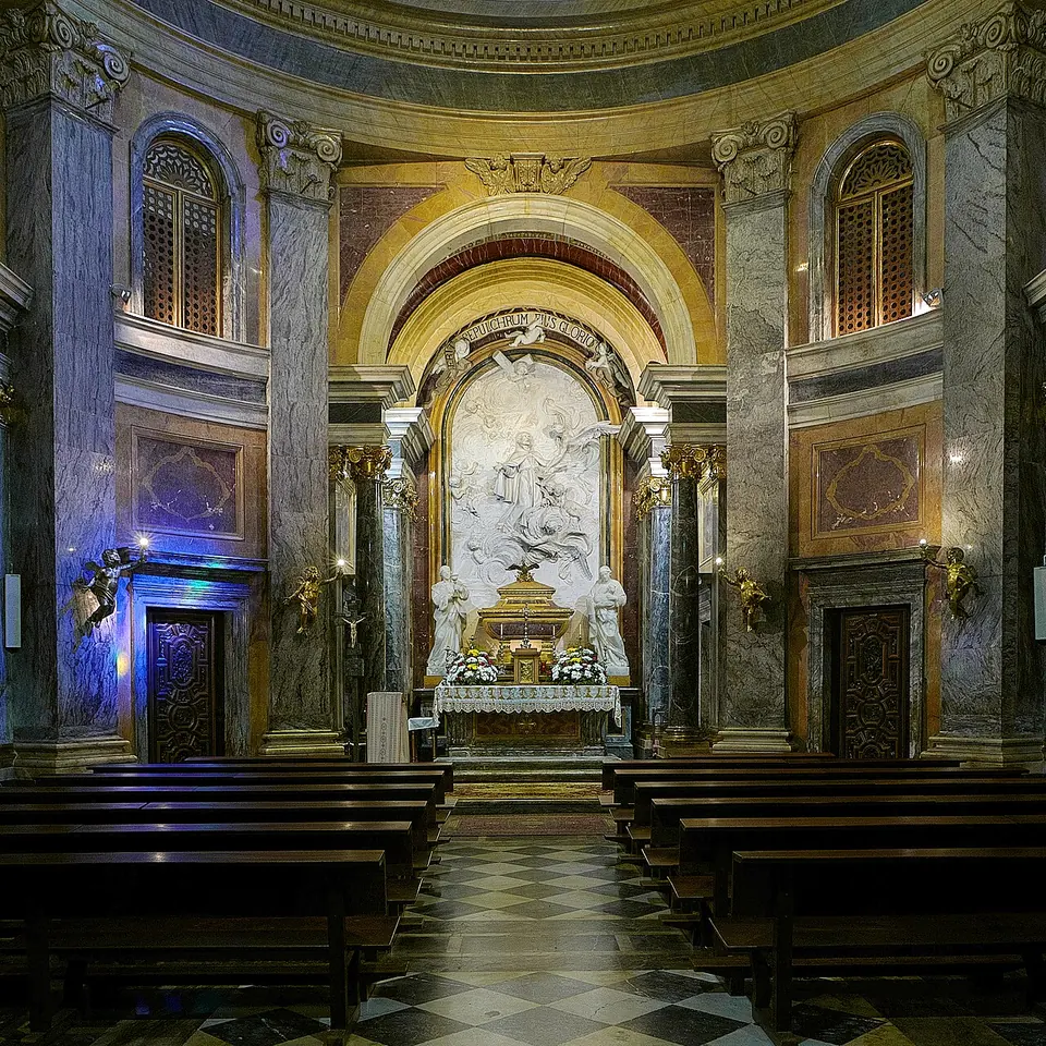A domed octagonal chapel of colored marble with a large white marble relief of a saint rising to heaven above the altar, and an urn on the altar flanked by statues