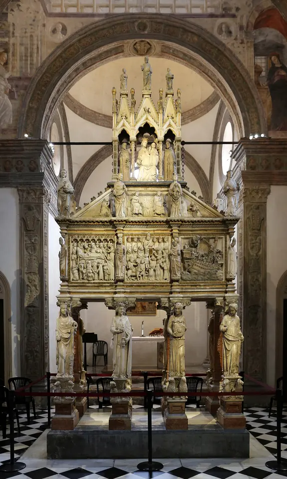 The white marble tomb of St. Peter Martyr in the Portinari Chapel, a carved sarcophagus raised on statues of the Virtues and crowned by a Gothic tabernacle with statues