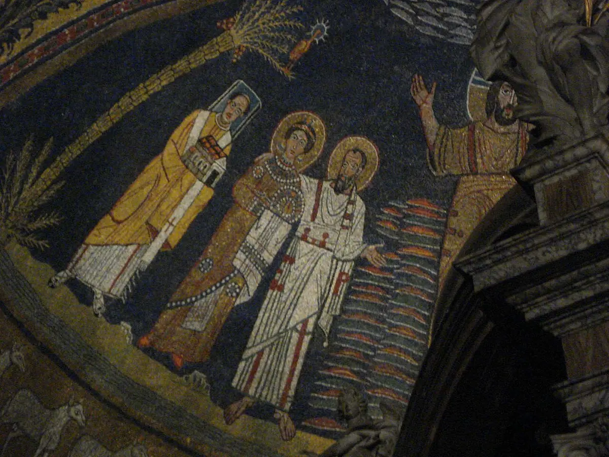 Mosaic detail of St. Paul in white with his hand on the shoulder of St. Praxedes, who wears a jeweled gown and holds a crown, beside Pope Paschal holding a model of the church