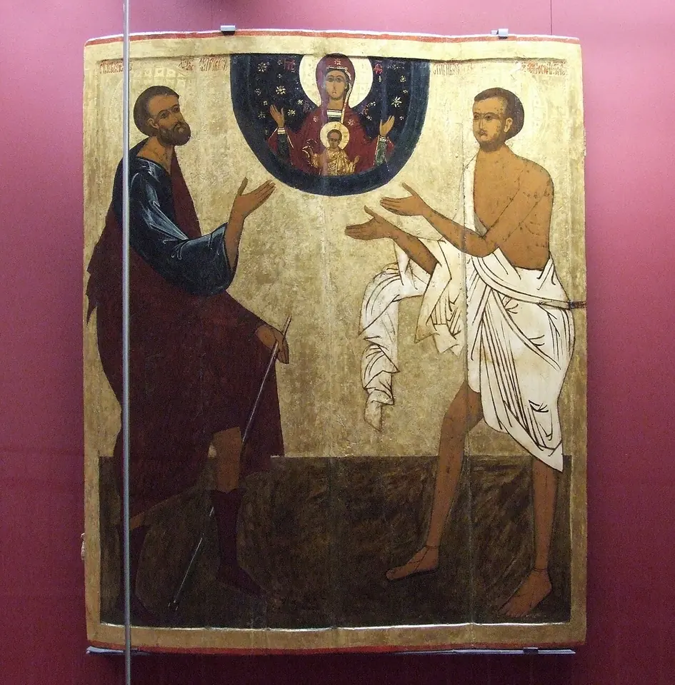 An icon of two holy fools standing with hands raised toward the Mother of God of the Sign, one bearded in a dark cloak holding staffs, the other younger and nearly naked in a white cloth
