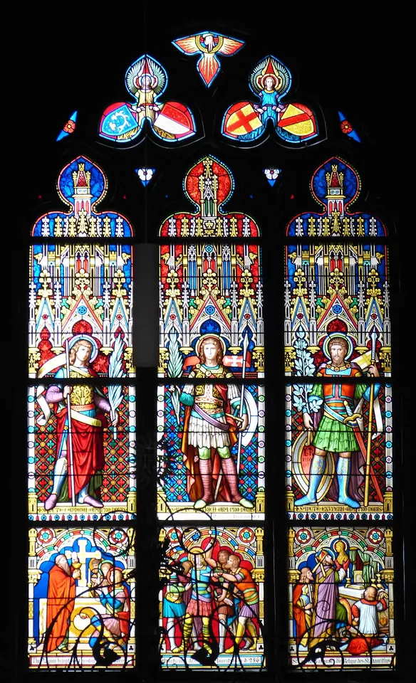 Tall Gothic Revival stained-glass window with three armored soldier saints standing under canopies, and scenes of their martyrdom in the lower panels