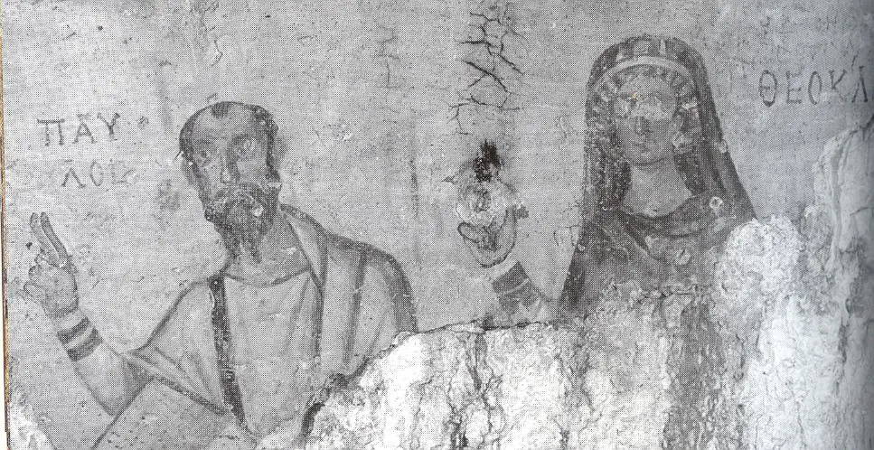 Faded black-and-white photograph of an early Byzantine wall painting of St. Paul raising his hand in teaching beside a veiled woman, with their Greek names written above them