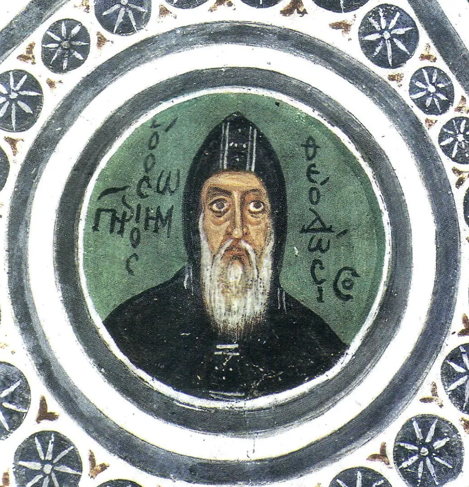 Round fresco medallion on a green ground of an old monk with a white beard and a dark hood, his name written in Greek on either side