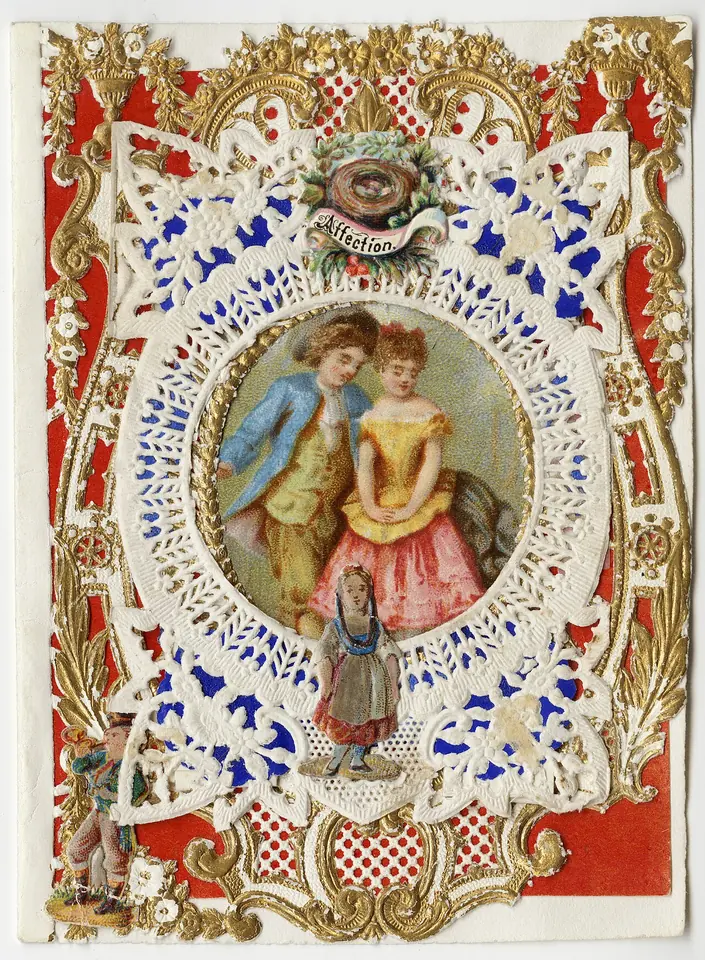 A Victorian valentine card of white paper lace and gold scrollwork on red, framing a colored print of a young couple and a small girl