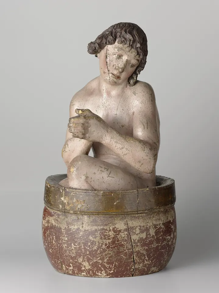 Small carved and painted wooden figure of a youth crouching in a round tub, hands joined in prayer, head tilted to one side
