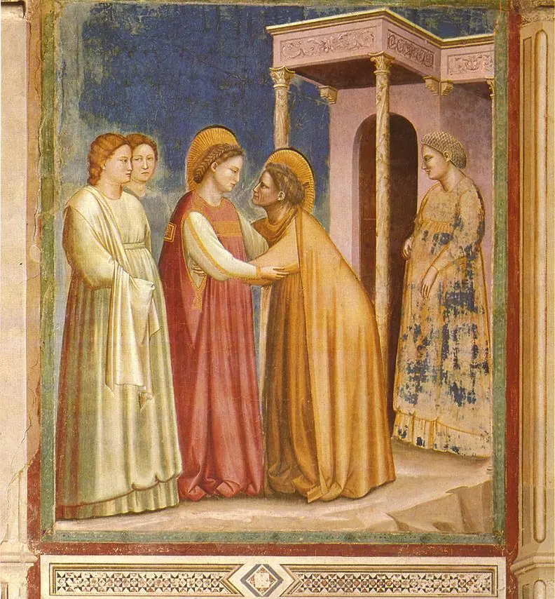 Fresco of Mary in a red mantle embracing the older Elizabeth, who bends toward her, with women watching beside a small columned porch