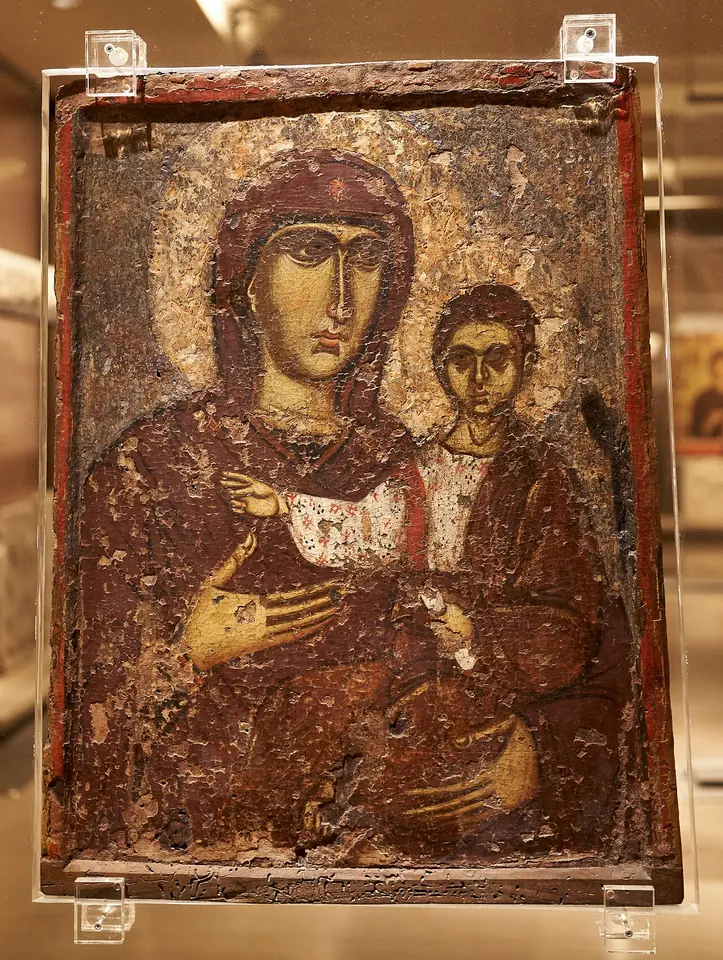 Worn Byzantine icon of Mary in a dark maphorion holding the Child on her left arm and gesturing toward him with her right hand